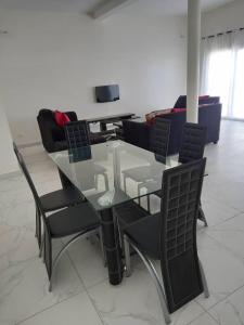 a glass table and chairs in a living room at Villa Diambars in Sali Tapé