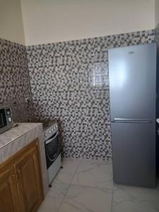 uma cozinha com um frigorífico e um fogão em Villa Diambars em Sali Tapé