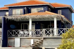 a blue house with an orange roof and a balcony at Villa Bahia Blue in Kralendijk
