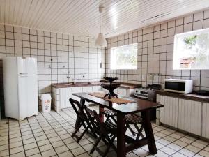 uma cozinha com uma mesa com cadeiras e um frigorífico em Villa Oloh com lazer completo em Caucaia - CE em Caucaia