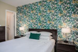 a bedroom with a large bed with a tropical wallpaper at The Local - St. Augustine in St. Augustine