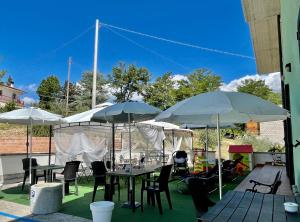 a patio with tables and chairs and umbrellas at B&b Villa Asia in Sulmona