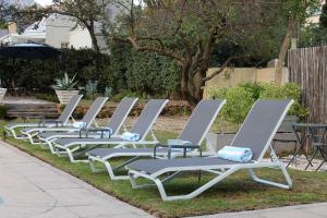 a row of lounge chairs sitting on the grass at LA RÉVERIE in Franschhoek