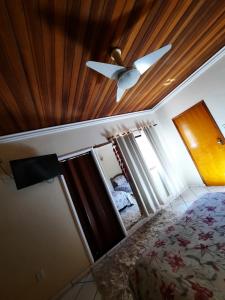 a bedroom with a ceiling fan and a bed at Casa da mãe in Aparecida