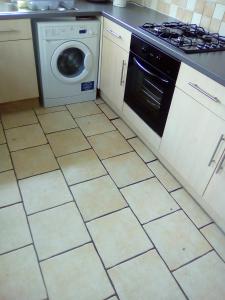 a kitchen with a stove and a washing machine at Spring Lodge in Bournemouth