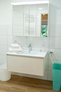 Baño blanco con lavabo y espejo en Ferienwohnung auf ehemaligen Bauernhof in der Nähe von Bamberg, en Walsdorf