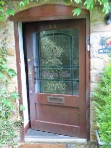 uma porta castanha com um sinal que lê a aldeia de Natal em Church Villa B & B em Chesterfield