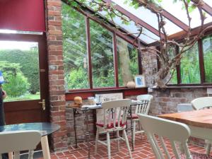 eine Terrasse mit Tischen, Stühlen und Fenstern in der Unterkunft Church Villa B & B in Chesterfield