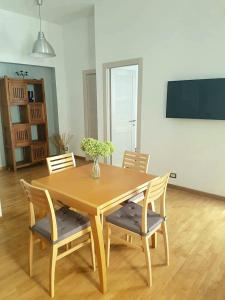 uma mesa de madeira com cadeiras e um vaso de flores em St Peter Charming House em Roma