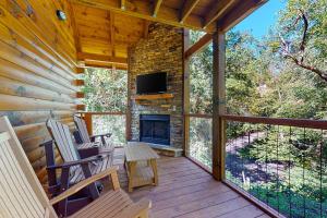 a screened porch with rocking chairs and a fireplace at Knotty Escape in Gatlinburg
