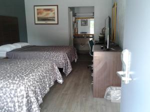 a hotel room with two beds and a television at Budget Inn Anderson in Anderson
