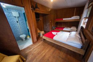 a bedroom with two bunk beds and a shower at Pousada Recanto Tropical in Ilha do Mel