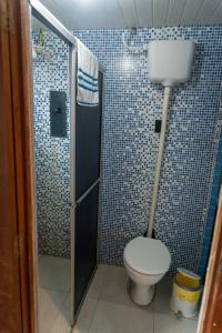 a bathroom with a toilet and a shower at Pousada Recanto Tropical in Ilha do Mel