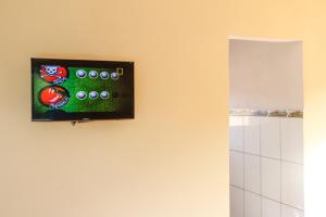 TV de pantalla plana colgada en la pared del baño en Fortuna Casas de Campo en Socorro