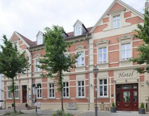 un gran edificio de ladrillo con un hotel en Gut Hotel Stadt Beelitz, en Beelitz
