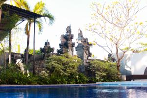 a resort with a swimming pool in front of a building at Putu Guest House 2 in Canggu