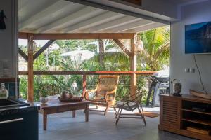 Il comprend une cuisine avec une terrasse dotée d'une table et de chaises. dans l'établissement BLUE DREAM SPA, à Les Trois-Îlets