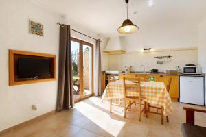 uma cozinha e sala de jantar com mesa e cadeiras em Monte do Tanoeiro - Casa Tonel em Rogil