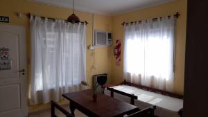 a living room with a table and a window at Guardalaola Patagonia Puelche in Las Grutas