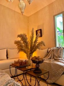 uma sala de estar com um sofá e uma mesa com xadrez em Riad Dar More em Marraquexe