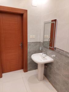 a bathroom with a sink and a mirror at المهيدب 3 للشقق المخدومة - اقتصادى in Buraydah +34 photos