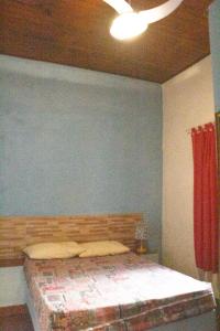 a bedroom with a bed and a blue wall at Casa do Carlos, praia da Enseada Ubatuba-SP in Ubatuba