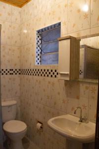a bathroom with a toilet and a sink and a window at Casa do Carlos, praia da Enseada Ubatuba-SP in Ubatuba +30 photos