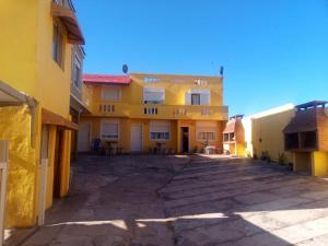 un aparcamiento vacío frente a un edificio amarillo en Complejo Al Mar en Las Toninas