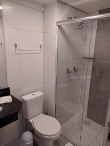 uma casa de banho com um WC e uma cabina de duche em vidro. em Hotel Aguadero em Passo Fundo