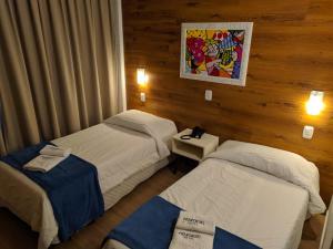 Cette chambre comprend deux lits. dans l'établissement Hotel Aguadero, à Passo Fundo