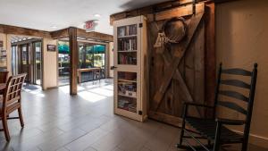 Pokój z drzwiami stodoły oraz stołem i krzesłami w obiekcie Best Western Inn & Suites Rutland-Killington w mieście Rutland