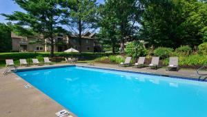 a swimming pool with lounge chairs and a house at Best Western Inn & Suites Rutland-Killington in Rutland