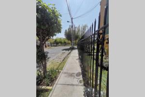 an iron fence on a sidewalk next to a street at Acogedora Casita independiente con estacionamiento in Arequipa