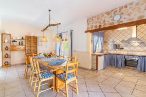 een keuken en eetkamer met een houten tafel en stoelen bij Villa Manuela in Portopetro
