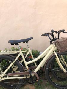 deux vélos garés l'un à côté de l'autre contre un mur dans l'établissement Pousada Vila Sergipana, à Barra dos Coqueiros