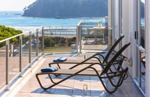 a wooden bench sitting on top of a patio at Belle Mer Beachfront Apartments - Self Serviced in Mount Maunganui