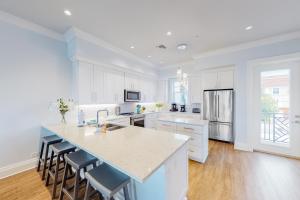 a kitchen with white cabinets and a large island at Brightwater Blue in Clearwater Beach