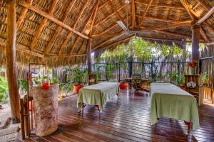 a room with two tables in a bamboo building at Morgan's Rock in San Juan del Sur