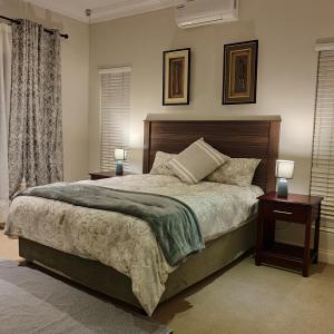 - une chambre avec un grand lit, 2 tables de nuit et 2 lampes dans l'établissement Verdant Valley Lodge, à Albert Falls