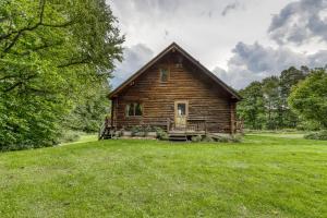 an old log cabin in a field of green grass at Log Cabin with a View in Andover