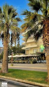 two palm trees in front of a hotel at Marina Premium Hotel in Vlorë