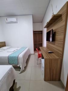Habitación de hotel con cama y TV en Pousada Nordestina en Riachão