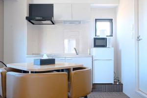 a kitchen with a table and chairs and a refrigerator at The Light Inn - Vacation STAY 94696 in Tokyo