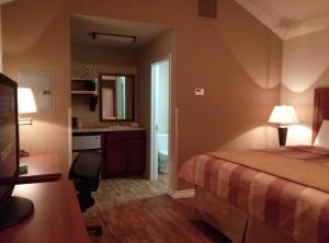 a hotel room with a bed and a bathroom at FieldHouse Inn & Conference Center in Kenedy