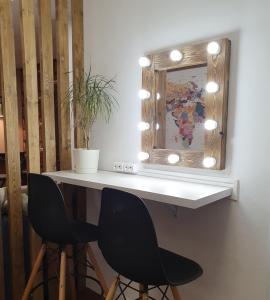 una mesa con 2 sillas negras y un espejo en Hostel Light Dream, en Moscú