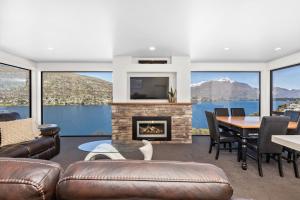 sala de estar con chimenea, mesa y sillas en Turua View, en Queenstown