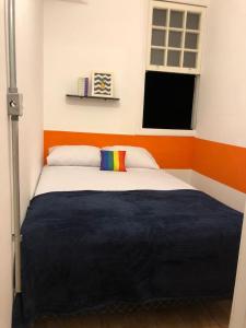 a bed in a room with a blue wall at Pinheiros Hostel & Food in Sao Paulo