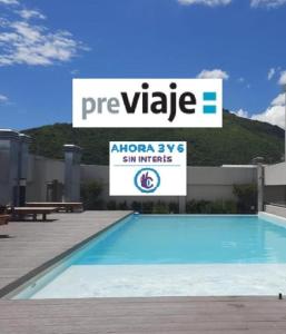 a large swimming pool with a sign in the background at AIRES VERDES PREMIUM in Salta