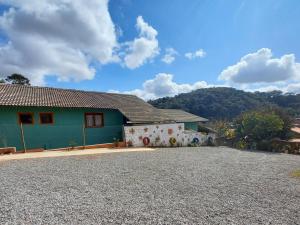 a house with a gravel driveway in front of it at Chalés Encantos de Cunha Rosa in Cunha