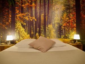 um quarto com uma cama numa floresta com dois candeeiros em Studio Camino Real em Saint-Jean-Pied-de-Port
